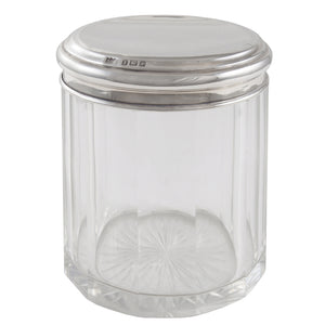 An early 20th century, glass jar with a silver lid