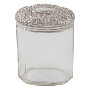 An Edwardian, glass jar with an embossed silver lid
