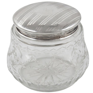 An early 20th century, engraved glass jar with an engine turned silver lid & vacant cartouche.