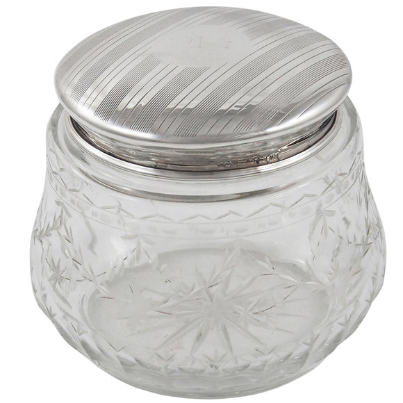 An early 20th century, glass jar with a silver lid