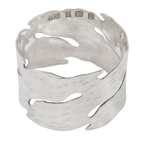 A modern, silver, wave napkin ring