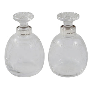 A pair of modern, cut glass scent bottles with silver mounts