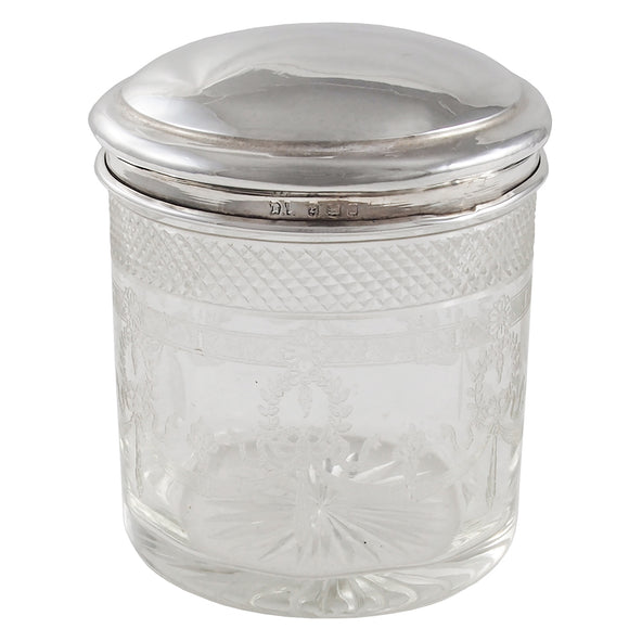 An early 20th century, glass jar with a silver lid