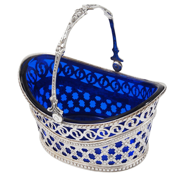 A Victorian, silver, lattice work sweet basket with a handle & blue glass liner