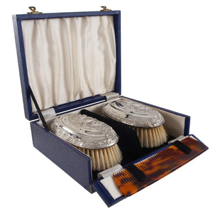 A pair of Edwardian, silver backed hair brushes, comb & fitted case