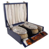 A pair of Edwardian, silver backed hair brushes, comb & fitted case.