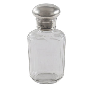 An early 20th century, faceted glass bottle with a silver lid.