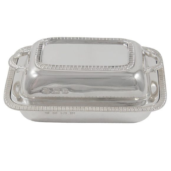 An early 20th century, silver butter dish in the shape of an entrée dish