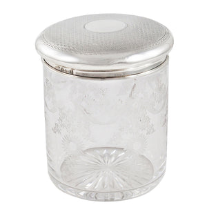 An early 20th century, glass jar with a silver lid