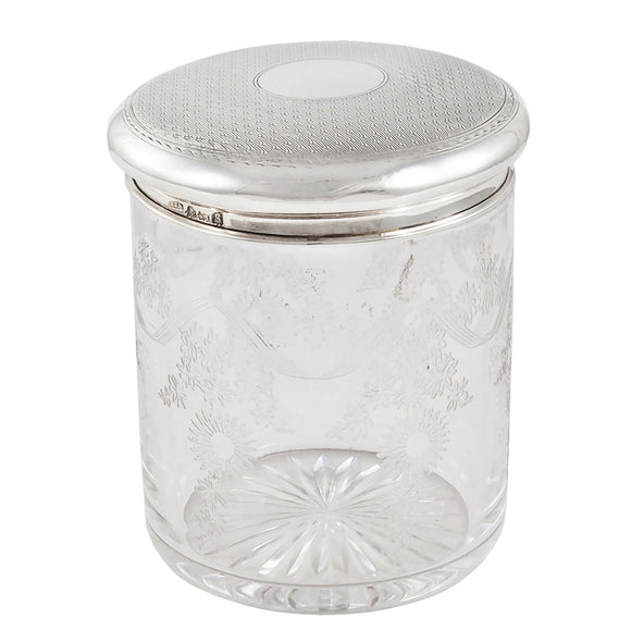 An early 20th century, glass jar with a silver lid