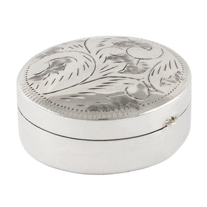 A modern, silver, circular pill box