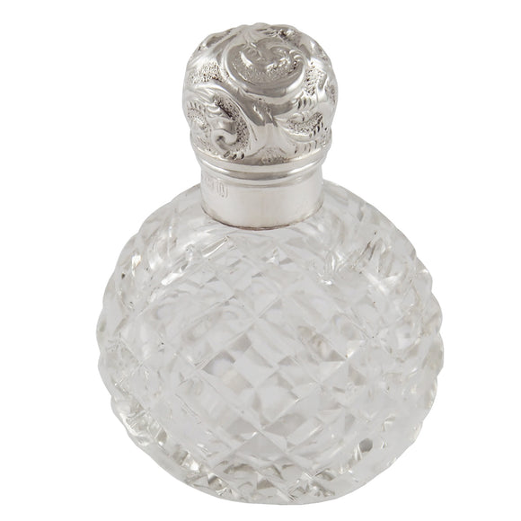 An Edwardian, cut glass perfume bottle with a silver lid