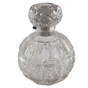 An Edwardian, glass perfume bottle with a glass stopper & silver hinged lid.