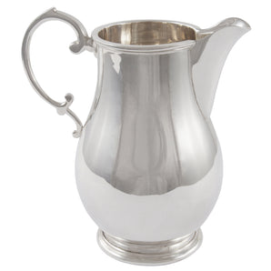 A modern, silver, baluster shaped cream jug, scroll handle & circular pedestal foot.
