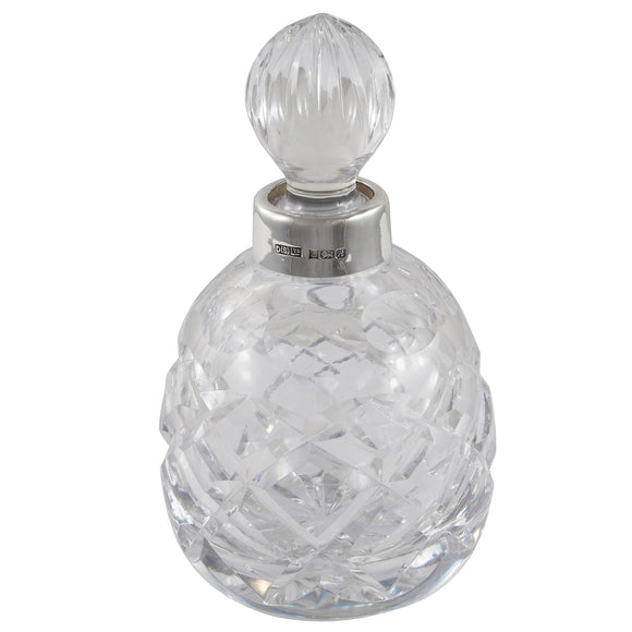 A modern, cut glass scent bottle with a silver mount