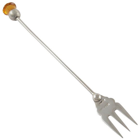 An Edwardian, white metal fork set with a yellow paste stone on the terminal end.