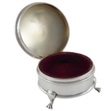 An early 20th century, silver, circular trinket box with red velvet lining.