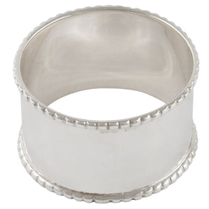A modern, silver napkin ring with a bead edge.