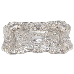 A Victorian, silver, rectangular pin tray with embossed floral & scroll decoration & vacant cartouche.